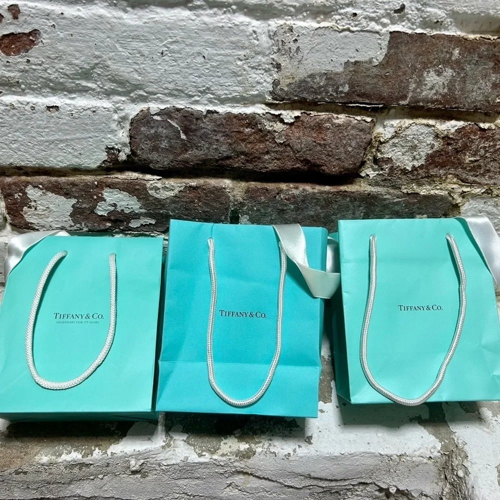 Set of three original Tiffany & Co blue bags and white ribbons.